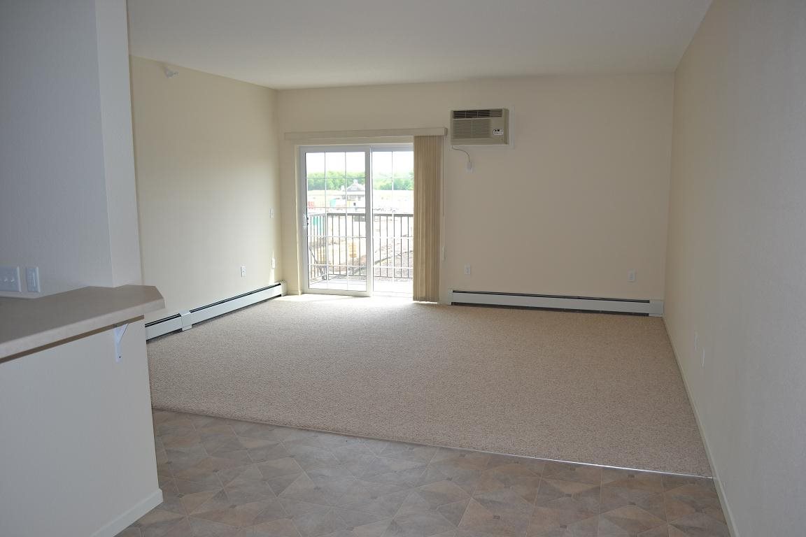 A room with a window and a door leading outside.